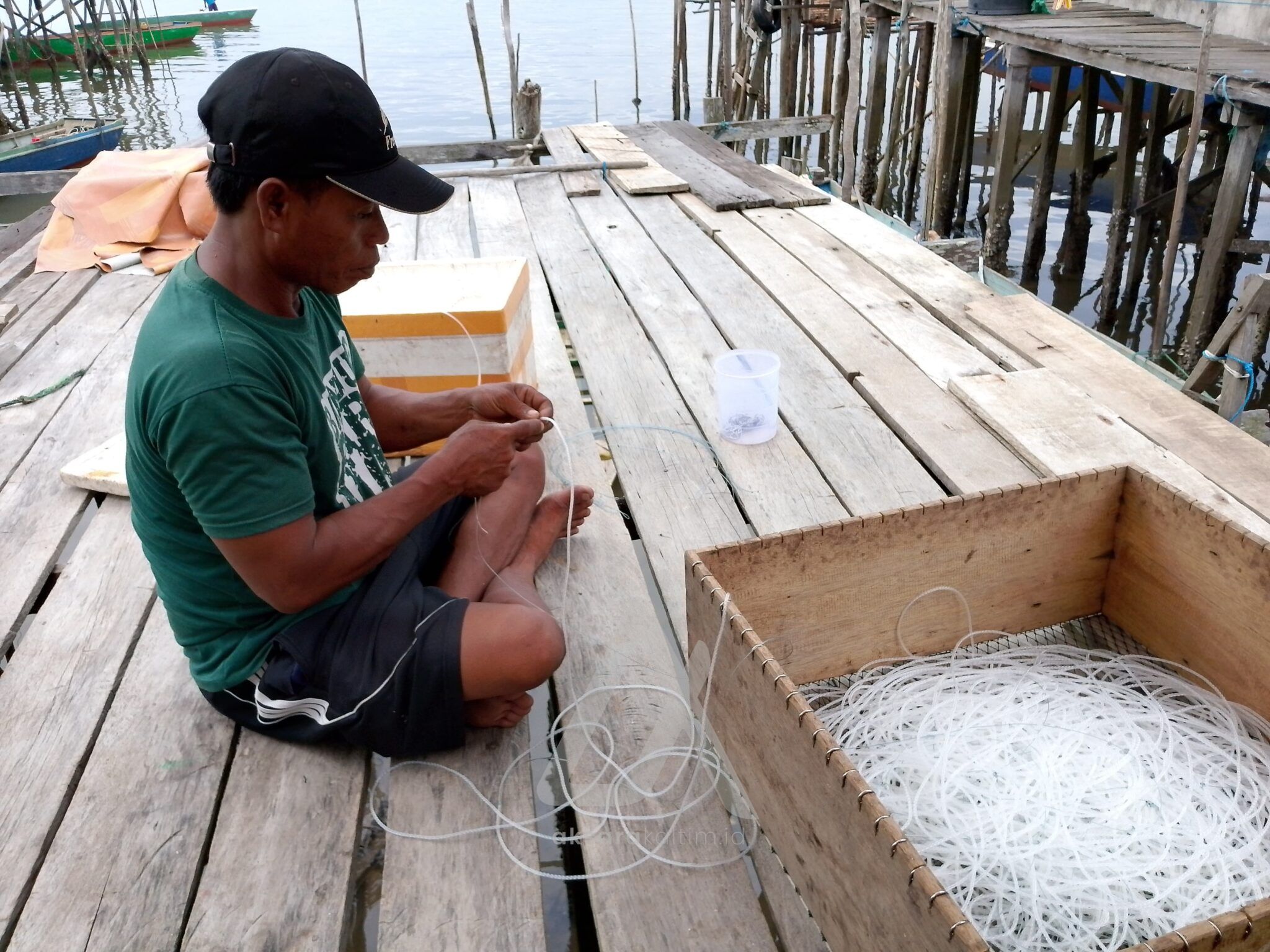 Warga Jenebora, Mansur sedang membuat pancing rawai di teras samping rumahnya. (Aksara Kaltim)