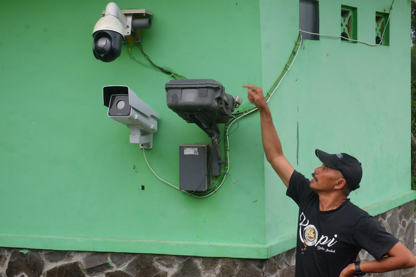 Pendiri Radio Komunitas Lintas Merapi, Sukiman Mochtar Pratomo menunjukkan kamera yang mengarah ke puncak Merapi dari arah Deles, Klaten, Jawa Tengah.